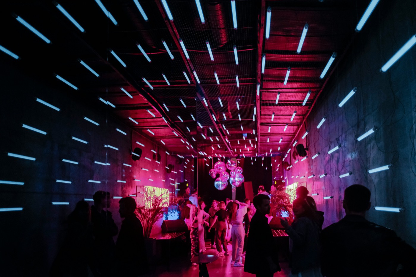 Club con iluminación de neón y público bailando
