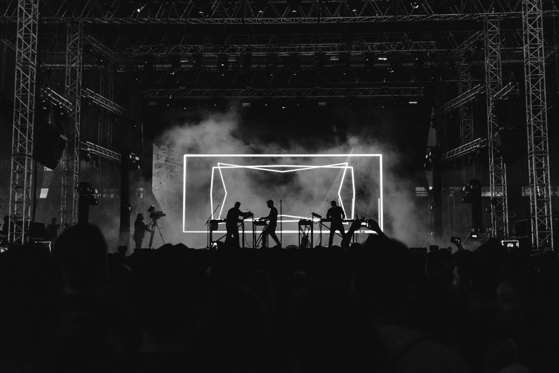Escenario de festival con luces y estructura de truss frente al público